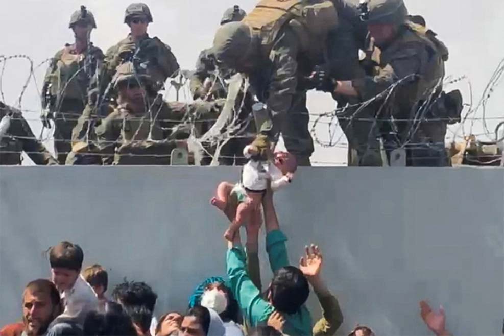 카불에서 미군에게 건네지고 있는 한 아기